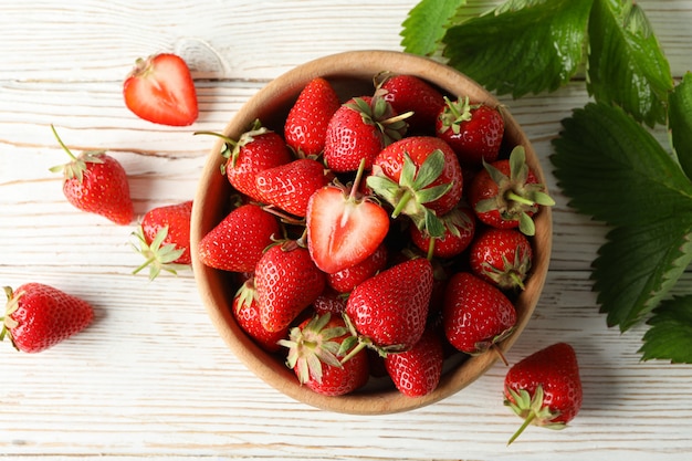 Bol avec savoureuse fraise sur table en bois