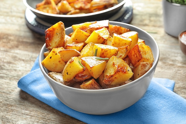 Bol avec de savoureux quartiers de pommes de terre sur table