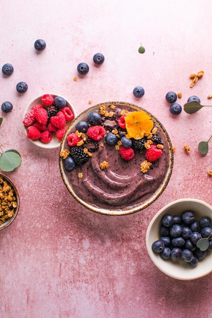 Bol de smoothie aux bleuets avec granola banane et graines de chia alimentation saine régime végétalien ou végétarien concept alimentaire fond clair