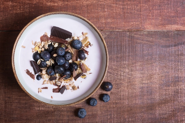 Bol à smoothie avec du yaourt naturel, des baies fraîches et des céréales