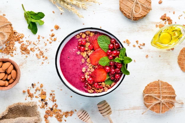 Bol de smoothie avec granola fraise groseilles rouges et menthe Petit-déjeuner Vue de dessus Espace libre pour votre texte