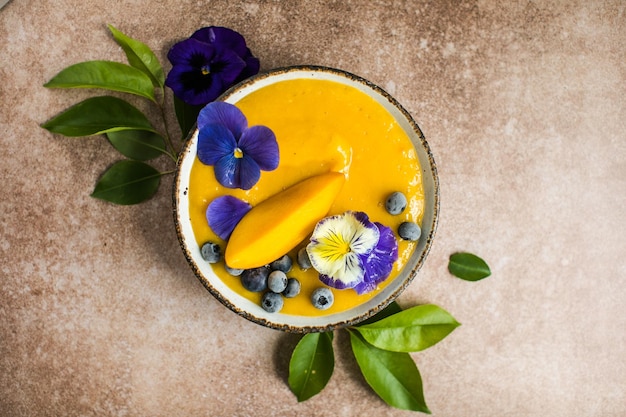 Bol de smoothie Mango Lassi au curcuma Fruits tropicaux frais sur fond clair Nourriture saine