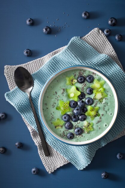 Bol de smoothie sain à la spiruline avec myrtille, étoiles de kiwi, graines de chia