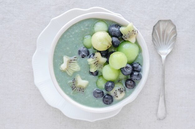 Bol de smoothie à la spiruline bleue avec melon, kiwi et myrtilles