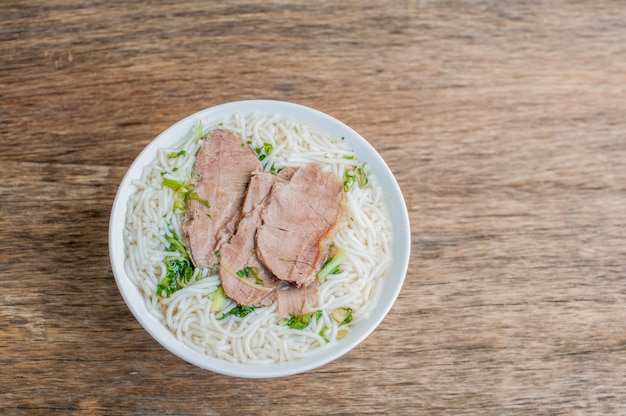 Bol de soupe au boeuf vietnamienne traditionnelle Pho Bo à l'arrière-plan en bois vieux sombre