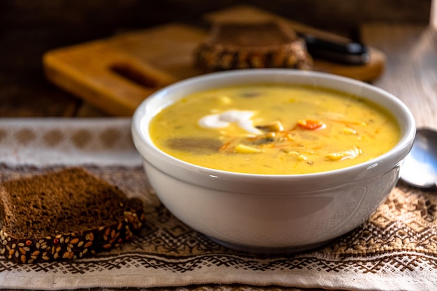 Photo un bol de soupe au poulet avec un morceau de pain sur une serviette