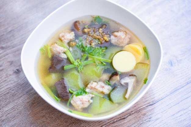 Bol de soupe au tofu avec des œufs de légumes au melon d'hiver Tranche de tofu Boule de viande et porc émincé au céleri, Soupe claire au sang de porc thaïlandais Nourriture saine asiatique sur fond sombre, vue de dessus