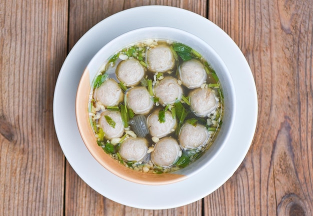 Bol de soupe aux boulettes de viande Boulettes de viande de cuisine thaïlandaise asiatique et boulettes de porc sur fond de bois