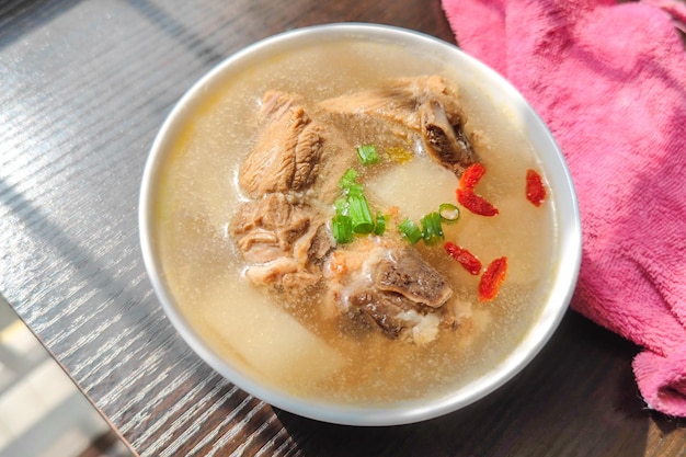 Un bol de soupe aux côtes de radis sur la table au soleil