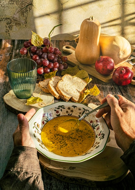 Bol de soupe à la citrouille chaude dans les mains Tenant un bol de soupe à la citrouille végétalienne Nourriture réconfortante Mise au point sélective