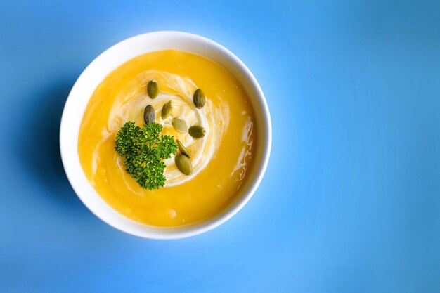 Bol de soupe à la citrouille avec feuille verte. Vue de dessus