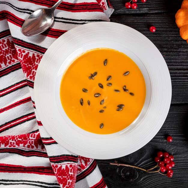 Photo un bol de soupe à la citrouille avec des graines dessus.