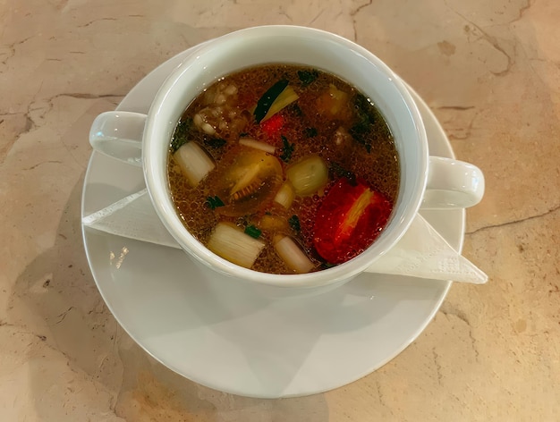 Un bol de soupe avec une cuillère sur une assiette