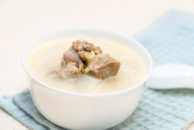 Un bol de soupe de mouton à l'étuvée de radis est placé sur la table à manger