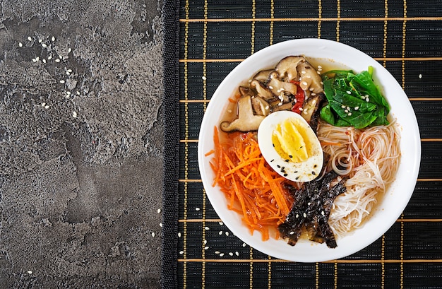 Bol de soupe de nouilles végétarienne aux champignons shiitake, carottes et œufs durs. Nourriture japonaise. Vue de dessus. Pose à plat