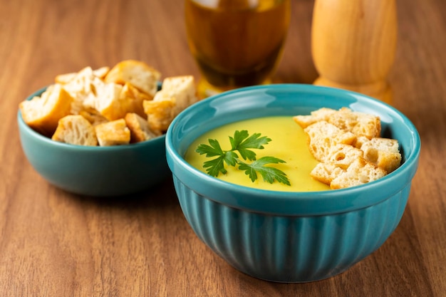 Bol avec soupe à l'oignon et croûtons sur la table.