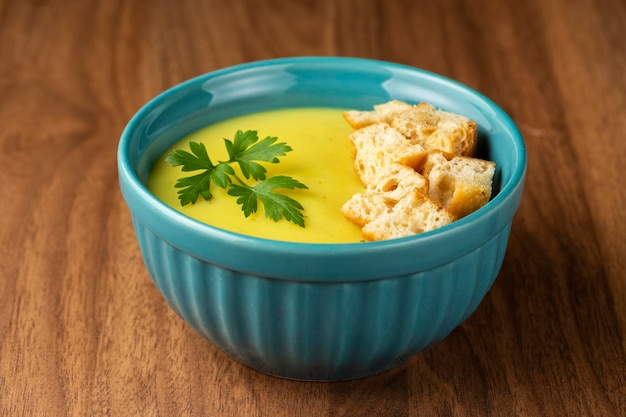 Bol avec soupe à l'oignon et croûtons sur la table.