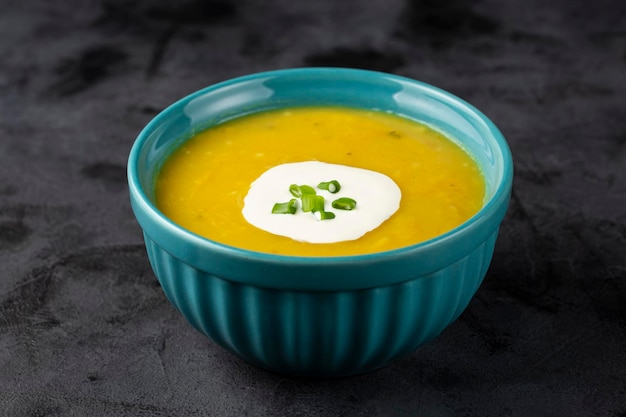 Bol avec soupe de potiron sur la table.