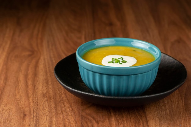 Bol avec soupe de potiron sur la table.