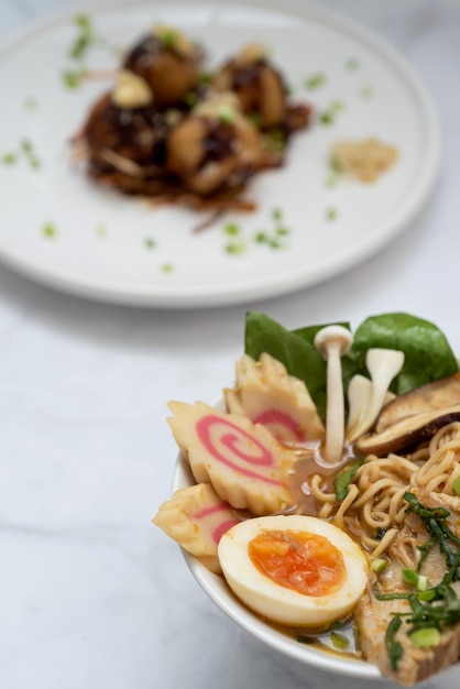 Un bol de soupe Ramen et une assiette de snack Takoyaki