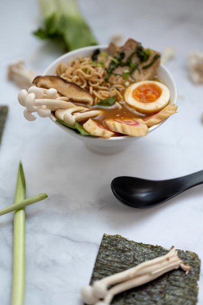 Photo un bol de soupe ramen avec tous les ingrédients sur une table en marbre