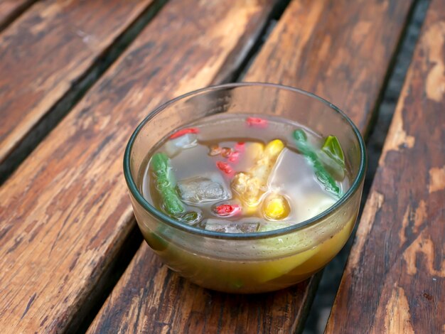 Un bol de soupe de tamarindes Sayur Asem une soupe indonésienne populaire sur une table en bois