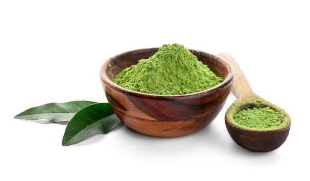 Bol avec thé matcha en poudre et cuillère sur fond blanc