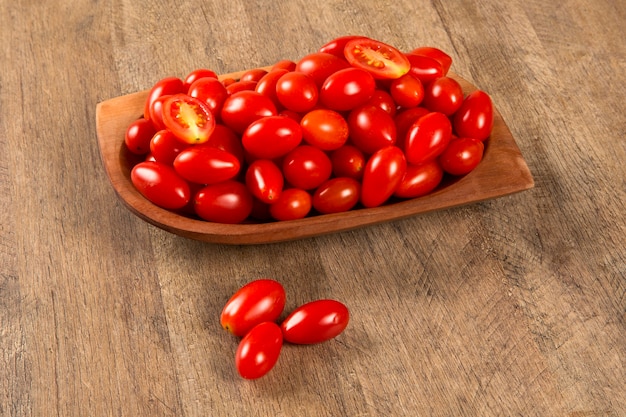 Un bol de tomates raisins sur une table en bois. Fruits frais.