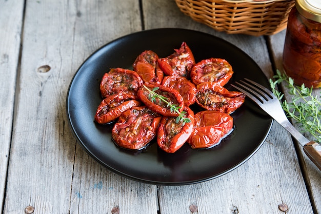 Bol de tomates séchées au soleil sur fond en bois. Tomates séchées à l&#39;huile d&#39;olive et aux herbes