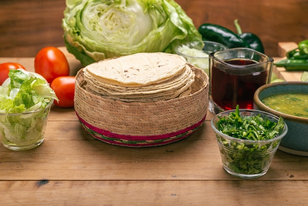 Bol de tortillas avec sauce verte et légumes sur une table en bois Cuisine mexicaine typique