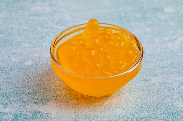 Photo bol en verre de bulles de perles de tapioca jaune sur fond bleu