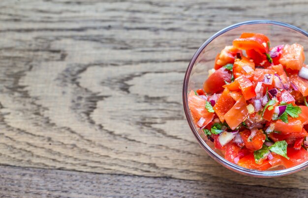 Bol en verre de salsa sur une table en bois