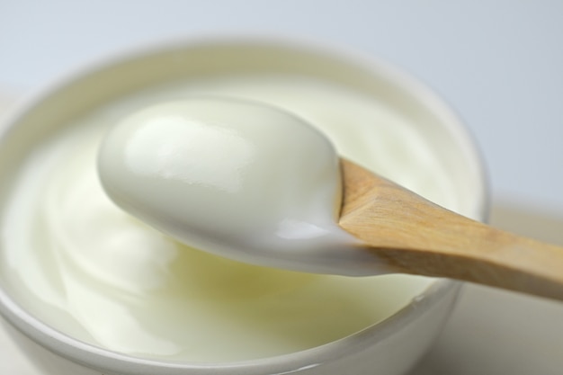 Bol de yaourt à la crème sure avec une cuillère en bois