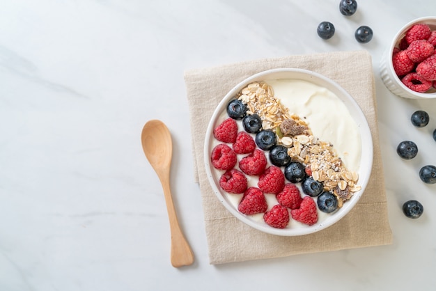 bol de yogourt fait maison avec framboises, myrtilles et granola - style alimentaire sain