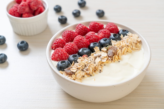 bol de yogourt fait maison avec framboises, myrtilles et granola - style alimentaire sain