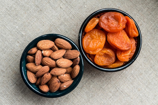 Bols aux amandes et abricots secs sur fond de toile