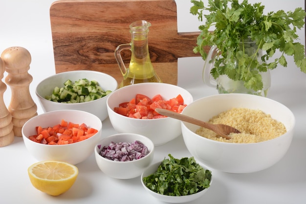 Photo bols blancs avec légumes râpés de différentes couleurs planche de cuisson avec ingrédients prêts pour la salade