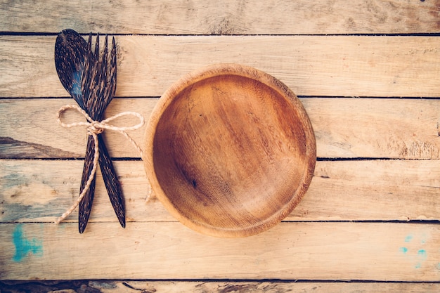 bols en bois et cuillère avec une fourchette sur fond de bois