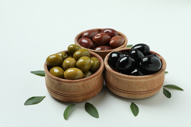 Bols en bois d'olives et de feuilles sur fond blanc