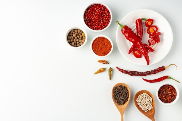 Bols avec épices et ingrédients de cuisine sur fond blanc