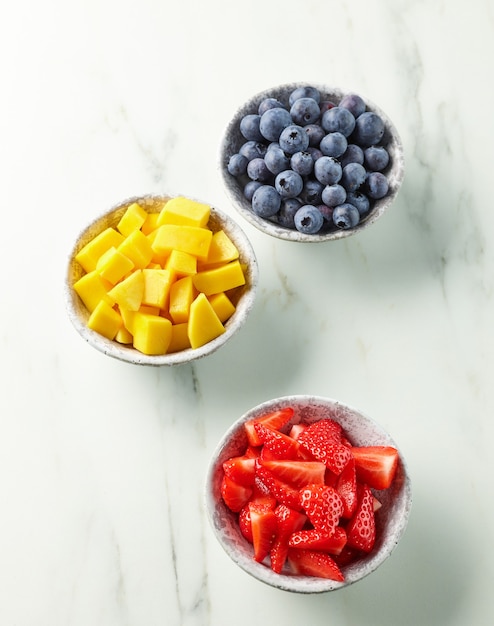 Bols de fruits frais et de baies pour un repas sain, vue de dessus