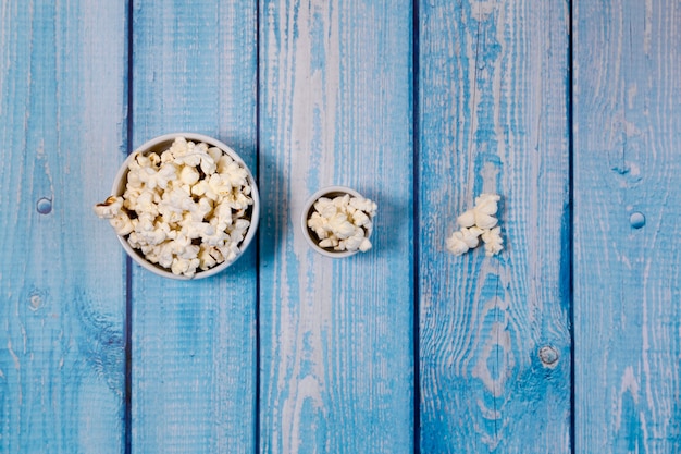 Bols de pop-corn sur table en bois bleu. Concept de visionnage de films en famille. Des films pour tous les âges.