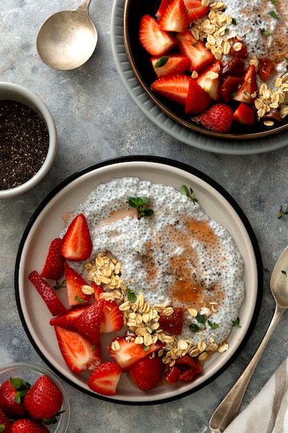 Bols de pudding aux graines de chia avec fraises et avoine. Petit-déjeuner sain, vue de dessus. Scène de la nourriture.