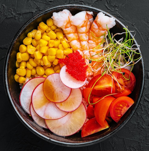 Bols avec de savoureuses crevettes de riz et légumes sur fond sombre