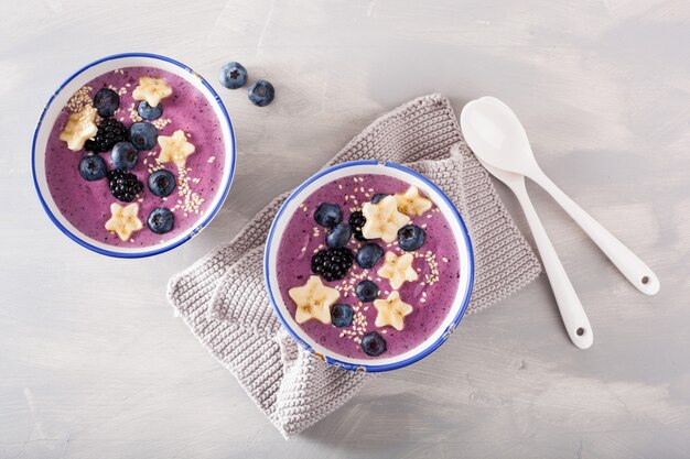 Bols de smoothie aux baies saines avec des graines de banane et de sésame