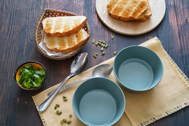 Bols à soupe vides et pain à proximité sur une vieille table en bois