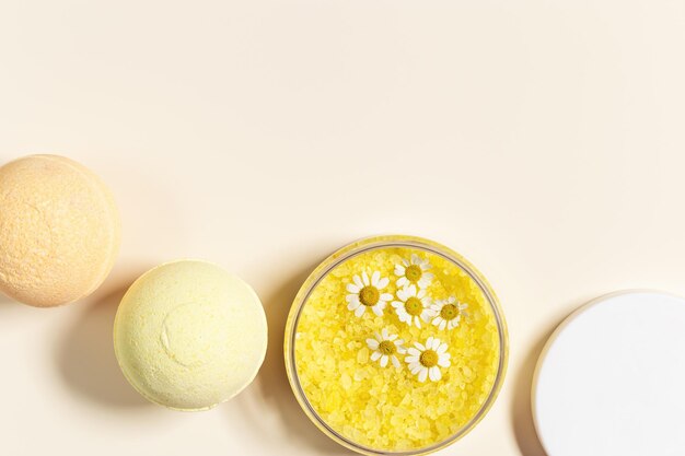 Bombe de bain bain de sel de mer avec extrait à base de plantes de camomille cristaux de salé de mer dans un pot fleurs de camomile naturelles concept de soins à domicile se détendre et se reposer procédure de bain soins corporels cosmétiques