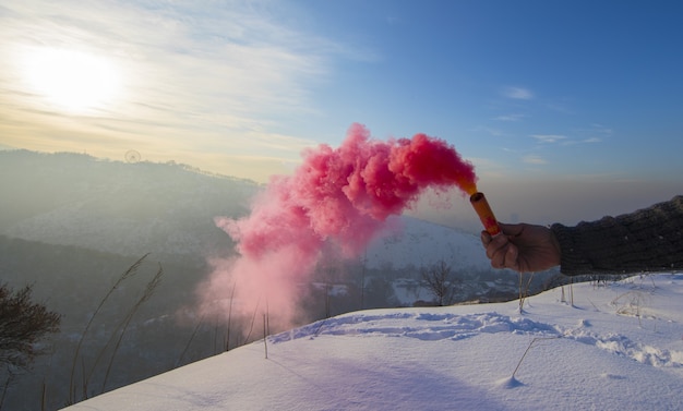 bombe fumigène rouge à la main