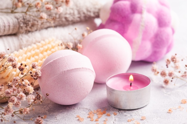 Bombes de bain arôme rose en arrangement SPA avec fleurs sèches et bougie allumée