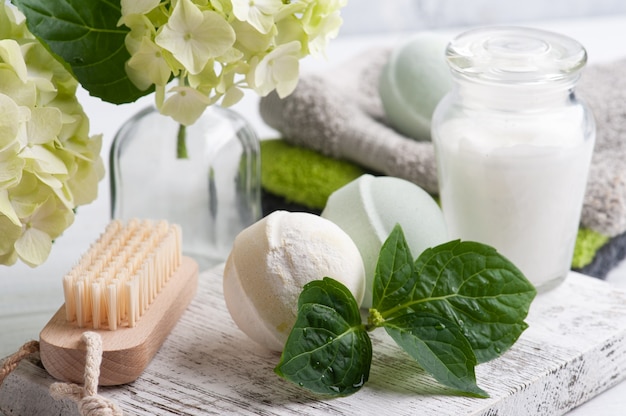 bombes de bain et bougie allumée à côté d'hortensia